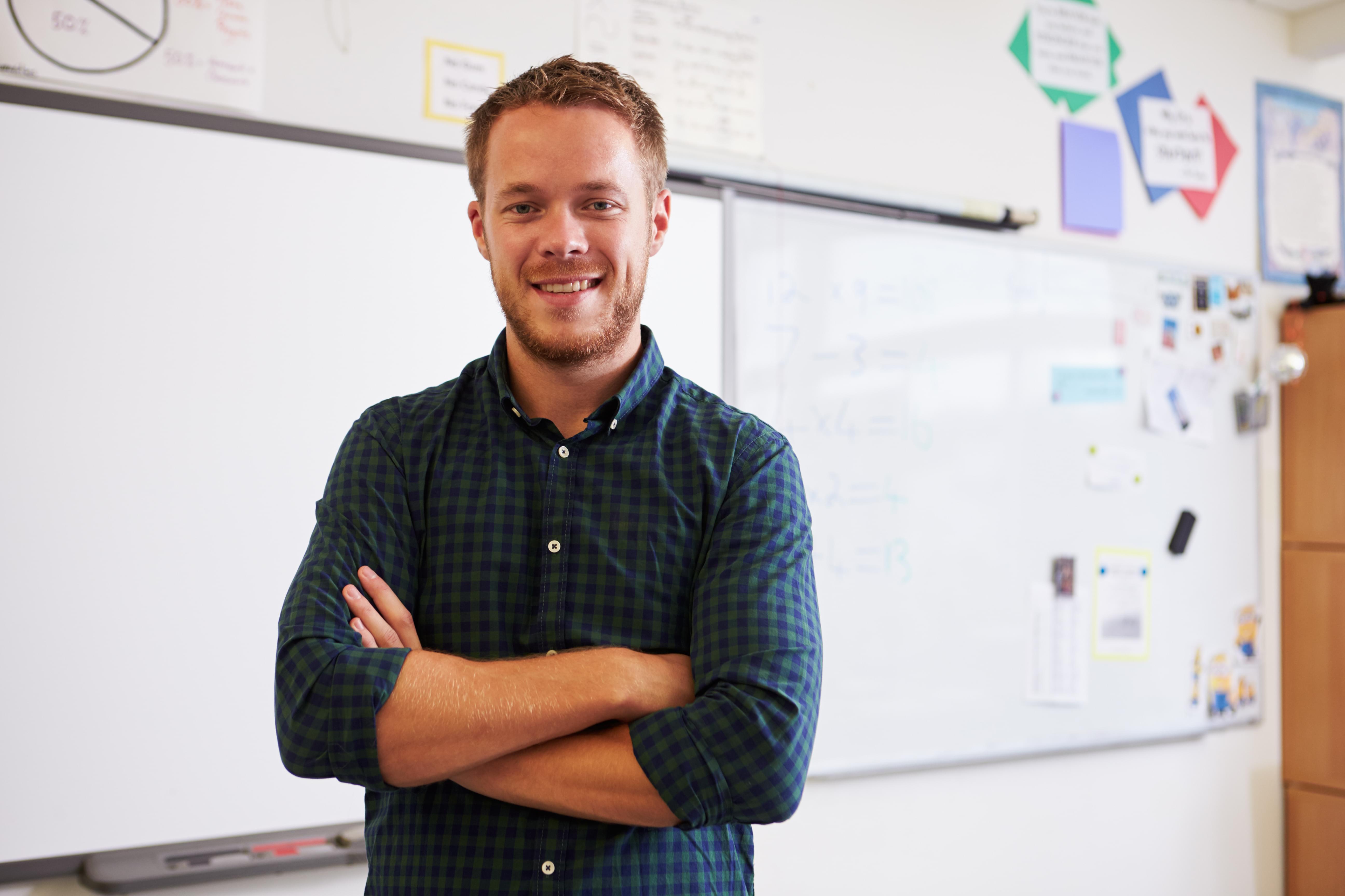 Calm, relaxed teacher in front of whiteboard